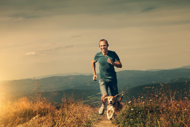 Man running with his dog on the mountain tableland